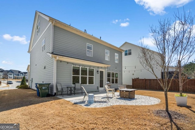 back of property featuring a fire pit, a patio area, and fence