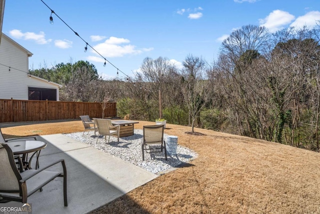 view of patio featuring fence and a fire pit