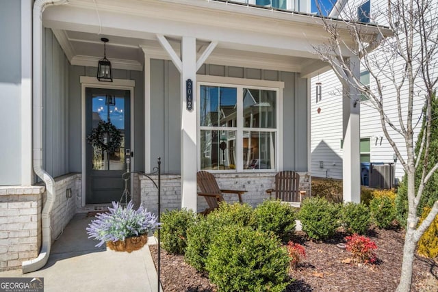 property entrance with covered porch and board and batten siding