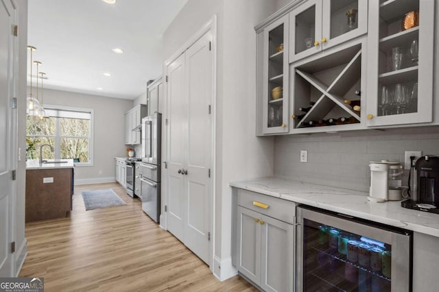 bar with wine cooler, light wood finished floors, tasteful backsplash, recessed lighting, and baseboards