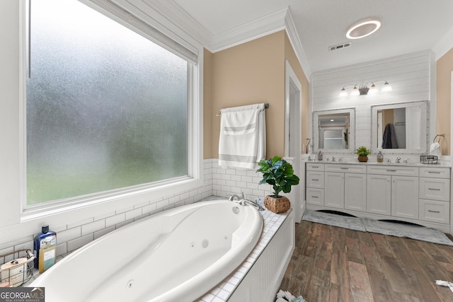 bathroom featuring double vanity, visible vents, ornamental molding, wood finished floors, and a jetted tub