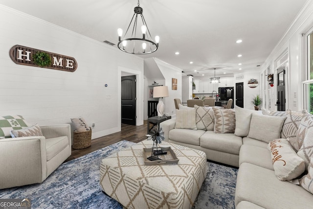 living area with visible vents, ornamental molding, wood finished floors, a notable chandelier, and recessed lighting