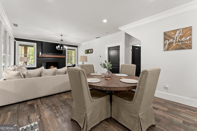 dining room featuring dark wood-style floors, a brick fireplace, crown molding, and baseboards