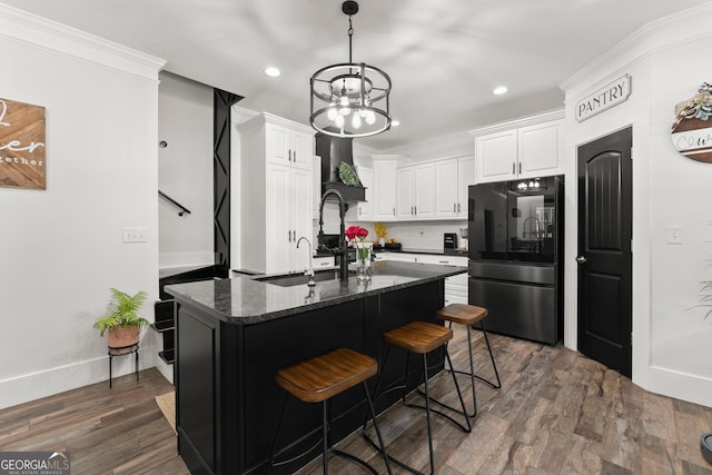 kitchen featuring dark wood-style flooring, crown molding, tasteful backsplash, freestanding refrigerator, and white cabinets