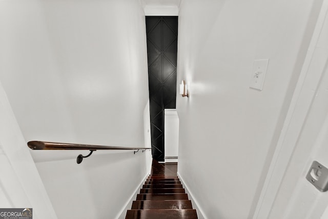 staircase with wood finished floors and baseboards