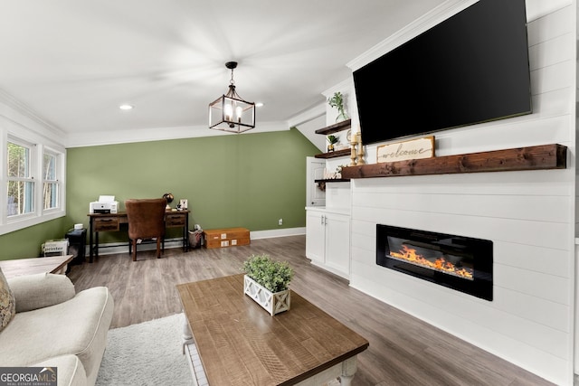 living area featuring a notable chandelier, baseboards, light wood finished floors, a glass covered fireplace, and crown molding