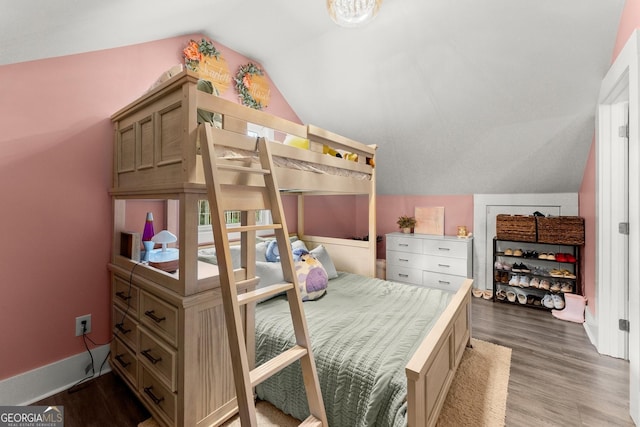 bedroom with baseboards, vaulted ceiling, and dark wood-type flooring