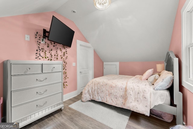 bedroom with lofted ceiling, baseboards, and wood finished floors