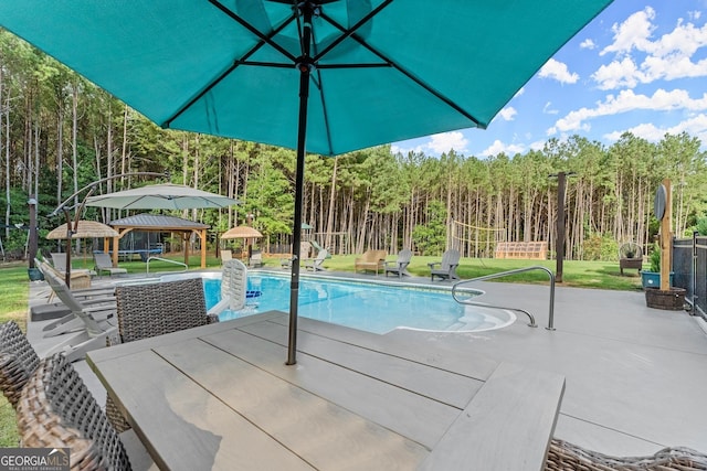 pool with fence, a gazebo, a yard, a patio area, and a wooded view