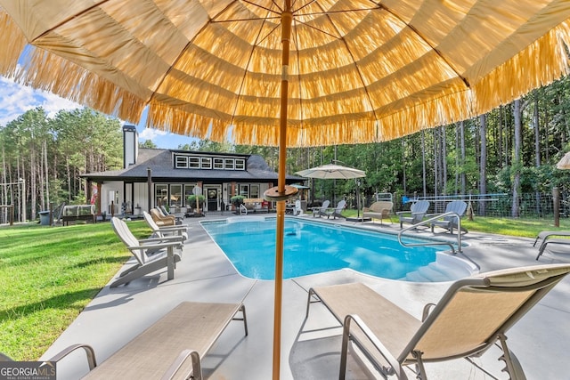 view of swimming pool featuring a patio, a yard, fence, and a fenced in pool