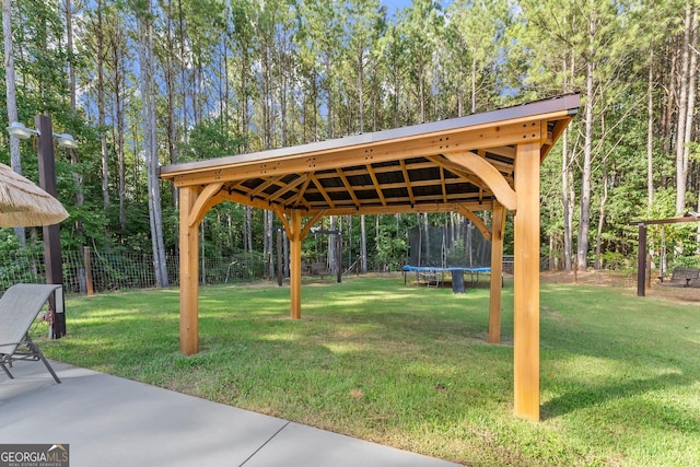 view of home's community with a trampoline, fence, a lawn, and a gazebo