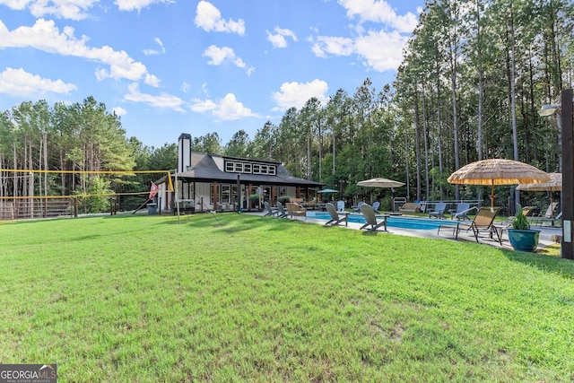 view of property's community with a yard, a swimming pool, and a patio area