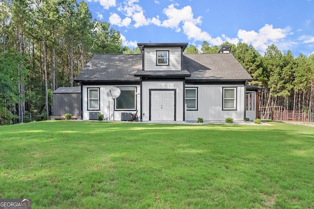 view of front facade with roof with shingles and a front lawn