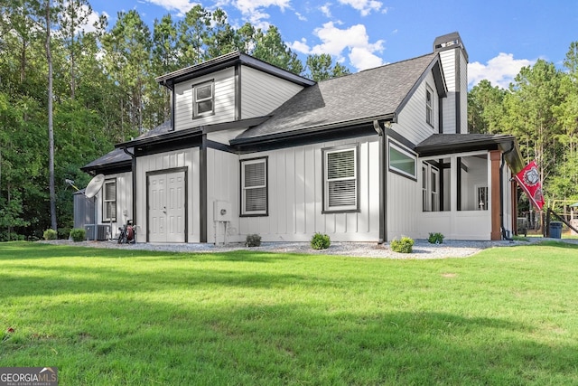 view of front facade featuring a shingled roof, a chimney, central air condition unit, a front lawn, and board and batten siding