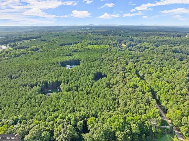 drone / aerial view featuring a wooded view