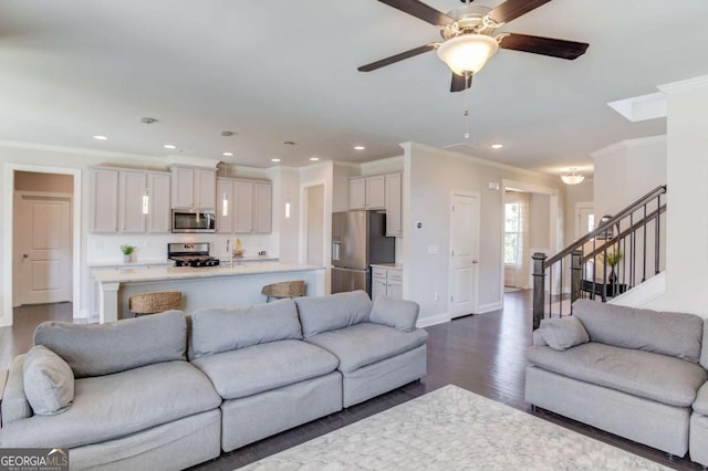 living area featuring recessed lighting, dark wood-style flooring, baseboards, ornamental molding, and stairway