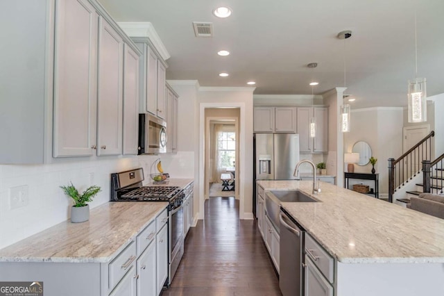 kitchen with appliances with stainless steel finishes, visible vents, ornamental molding, and tasteful backsplash