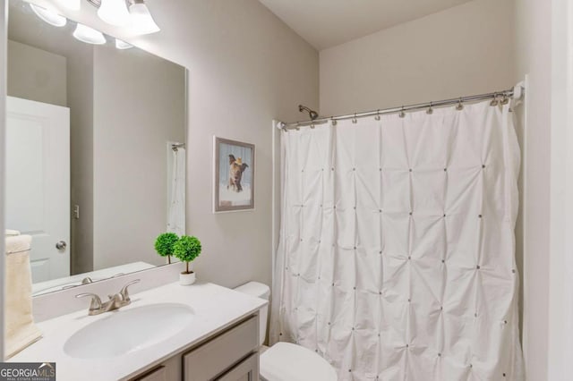 full bathroom with curtained shower, vanity, and toilet