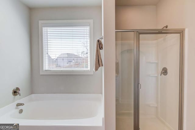 bathroom featuring a stall shower and a garden tub