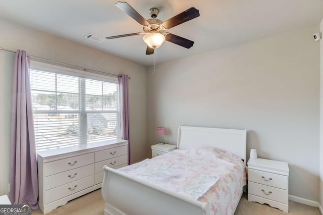 bedroom featuring a ceiling fan, visible vents, and light colored carpet