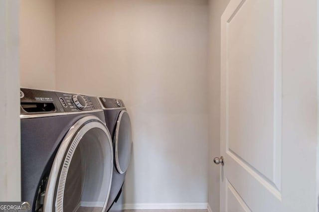 washroom featuring laundry area, baseboards, and independent washer and dryer