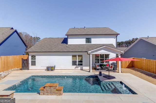 rear view of property featuring a patio area, a fenced backyard, and a fenced in pool