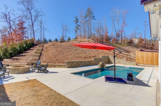 pool featuring an outdoor fire pit, a patio area, and fence