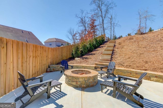 view of patio / terrace with an outdoor fire pit, stairs, and fence