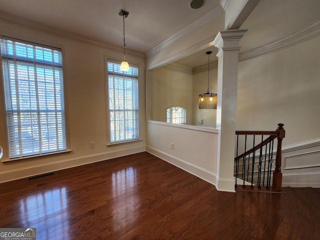 unfurnished dining area with visible vents, baseboards, wood finished floors, crown molding, and ornate columns