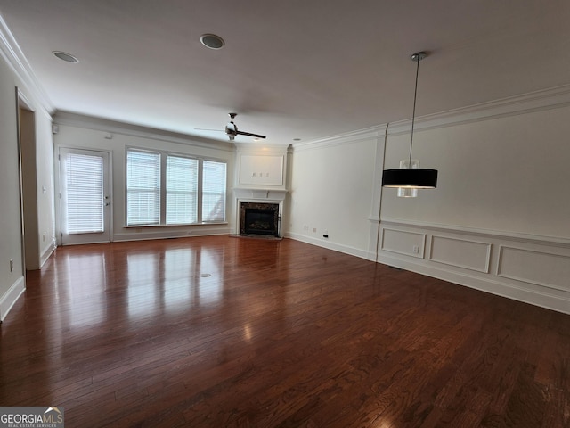 unfurnished living room featuring ornamental molding, dark wood finished floors, a ceiling fan, and a high end fireplace