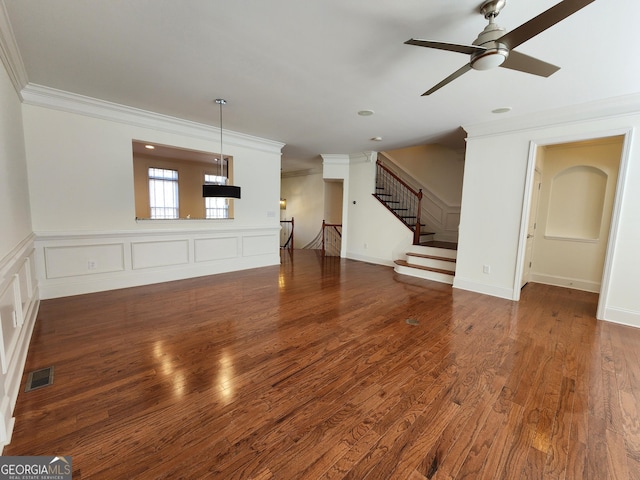 unfurnished living room with wood finished floors, visible vents, and crown molding