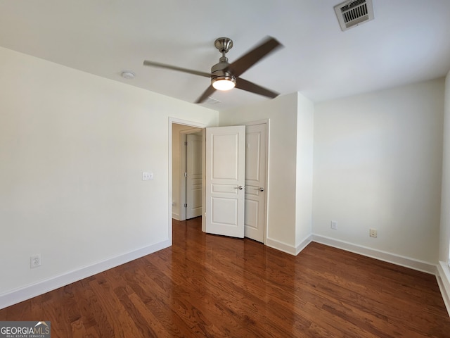 unfurnished bedroom featuring a ceiling fan, visible vents, baseboards, and wood finished floors