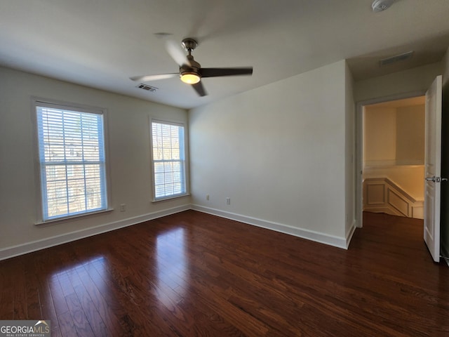 unfurnished bedroom with dark wood-type flooring, visible vents, and baseboards