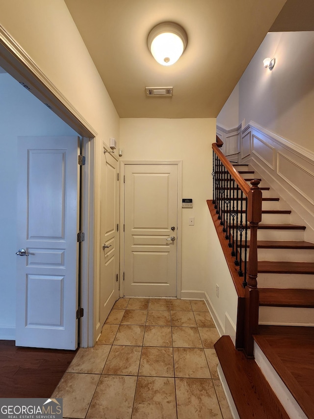 interior space with stairs, visible vents, and light tile patterned floors