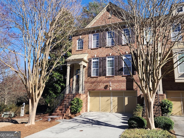 view of front of property with concrete driveway, brick siding, and an attached garage