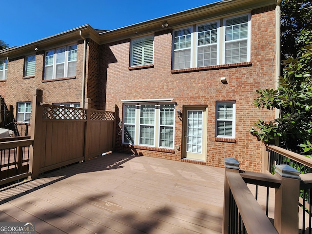 rear view of house with brick siding and a deck