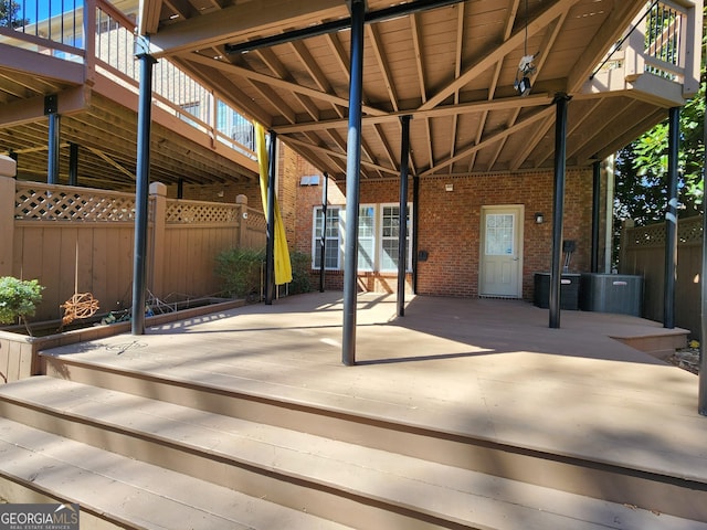 view of patio / terrace featuring central AC unit, a wooden deck, and fence