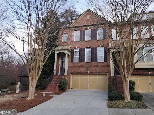 view of property with a garage, concrete driveway, and brick siding