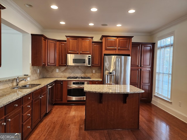 kitchen with dark wood-style flooring, light stone counters, stainless steel appliances, and a sink