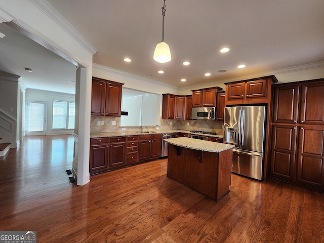 kitchen featuring appliances with stainless steel finishes, dark wood-style flooring, a kitchen island, and decorative backsplash