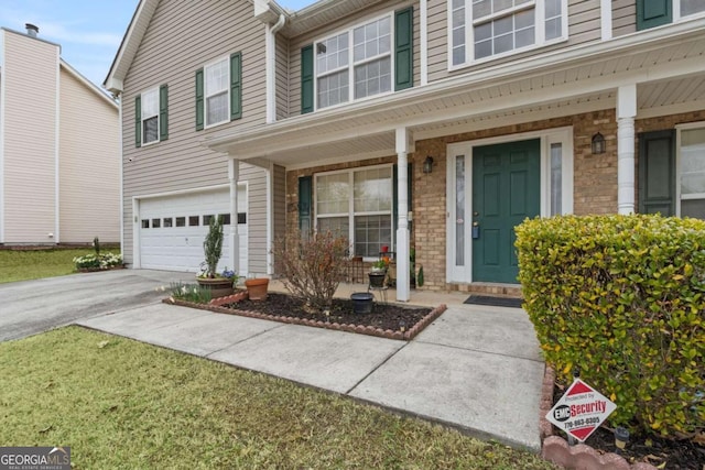 view of front of house featuring a garage, concrete driveway, brick siding, and a porch