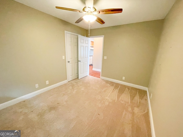 unfurnished bedroom with baseboards, a ceiling fan, and light colored carpet