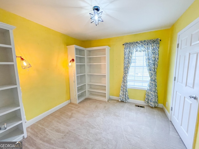 unfurnished room with visible vents, baseboards, and carpet flooring