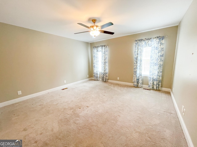 unfurnished room featuring light carpet, a wealth of natural light, and baseboards