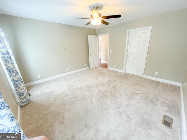 unfurnished bedroom with carpet floors, visible vents, baseboards, and a ceiling fan