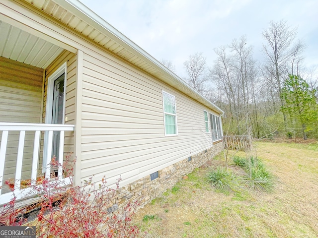 view of side of home featuring crawl space and a lawn