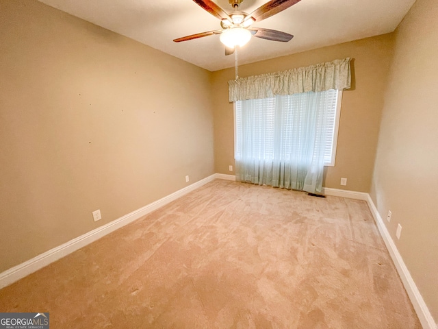 spare room with visible vents, carpet flooring, a ceiling fan, and baseboards