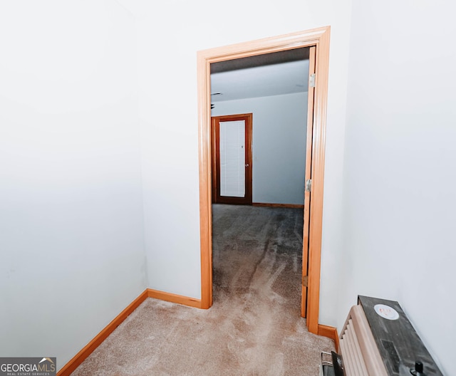 corridor featuring carpet flooring and baseboards