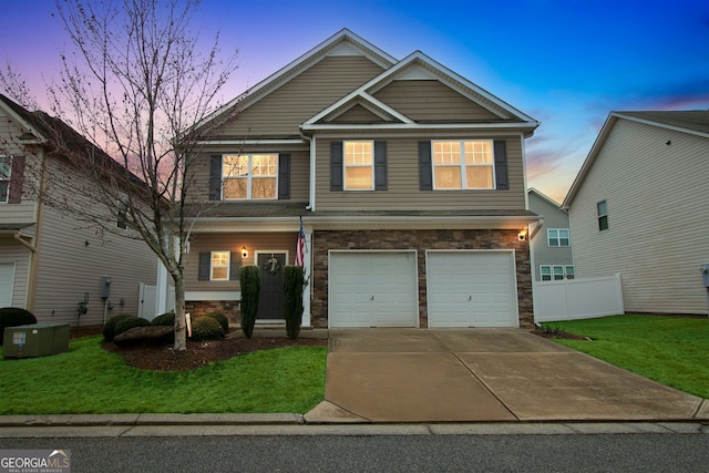 view of front of property with stone siding, fence, a yard, concrete driveway, and an attached garage