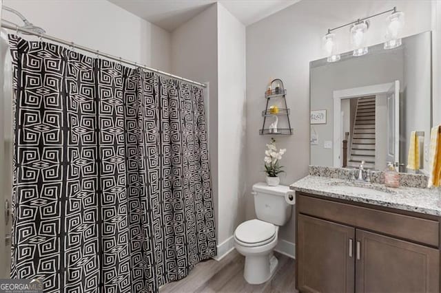 bathroom featuring baseboards, toilet, wood finished floors, curtained shower, and vanity